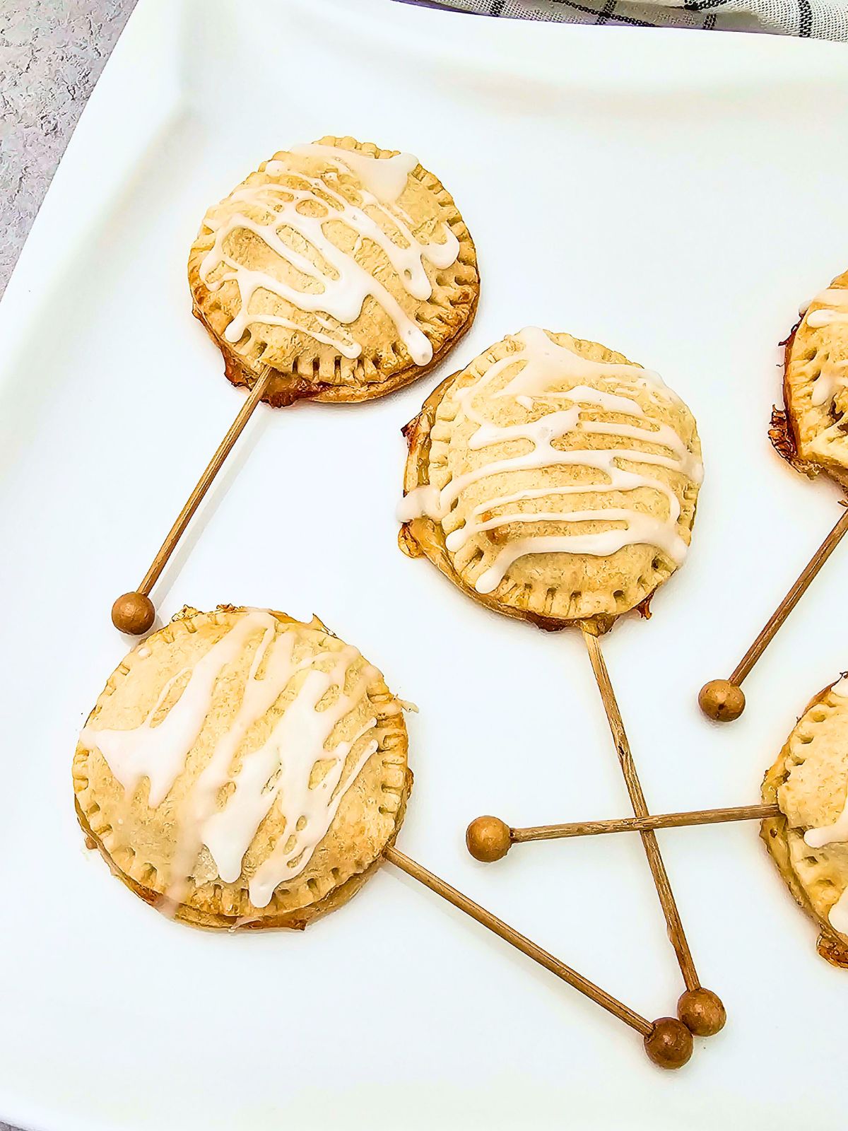 Apple pie pops on a white serving tray.