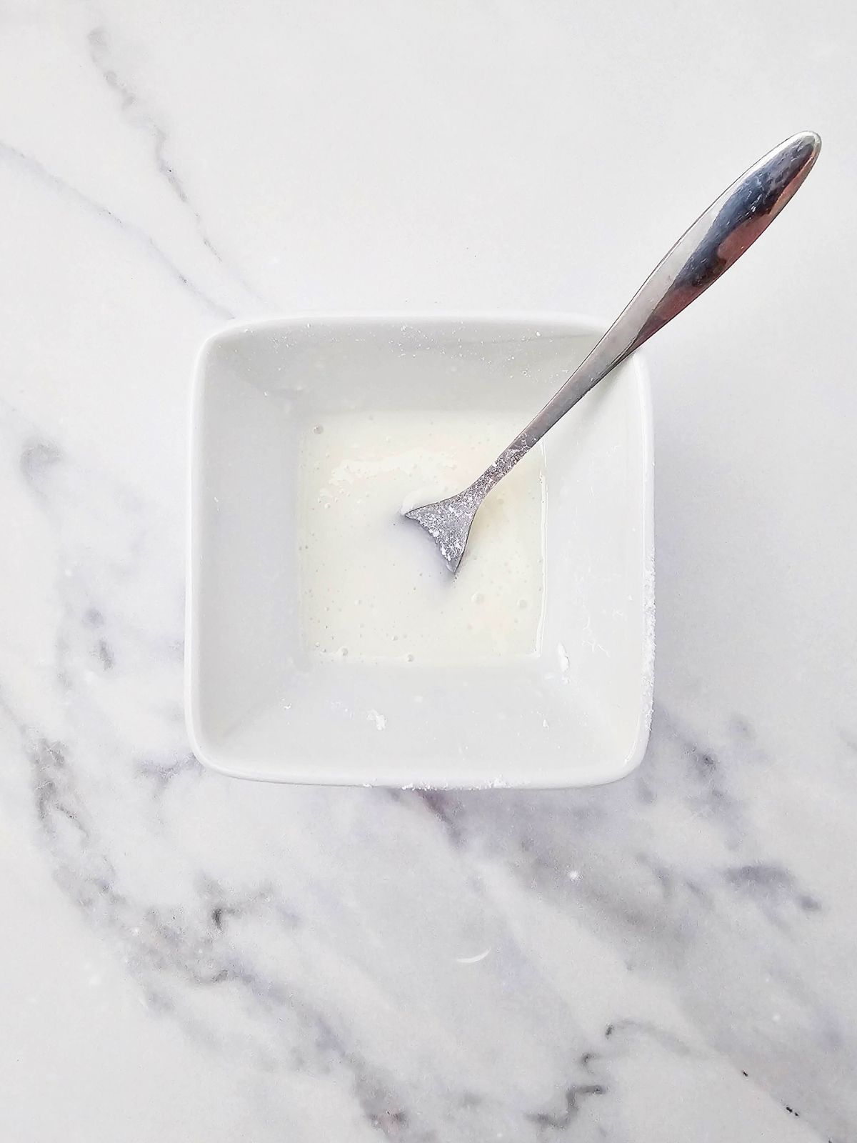 Mixing the icing sugar and milk in a small bowl.