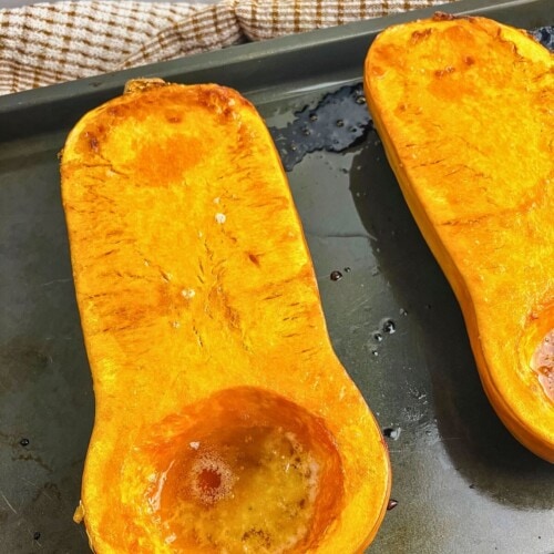 Whole roasted butternut squash with brown sugar on a baking sheet.