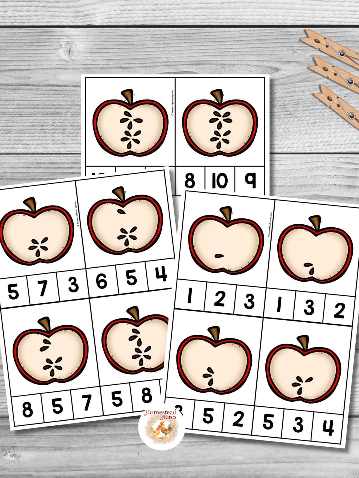 Three pages of apple seed count and clip cards on a wooden table.