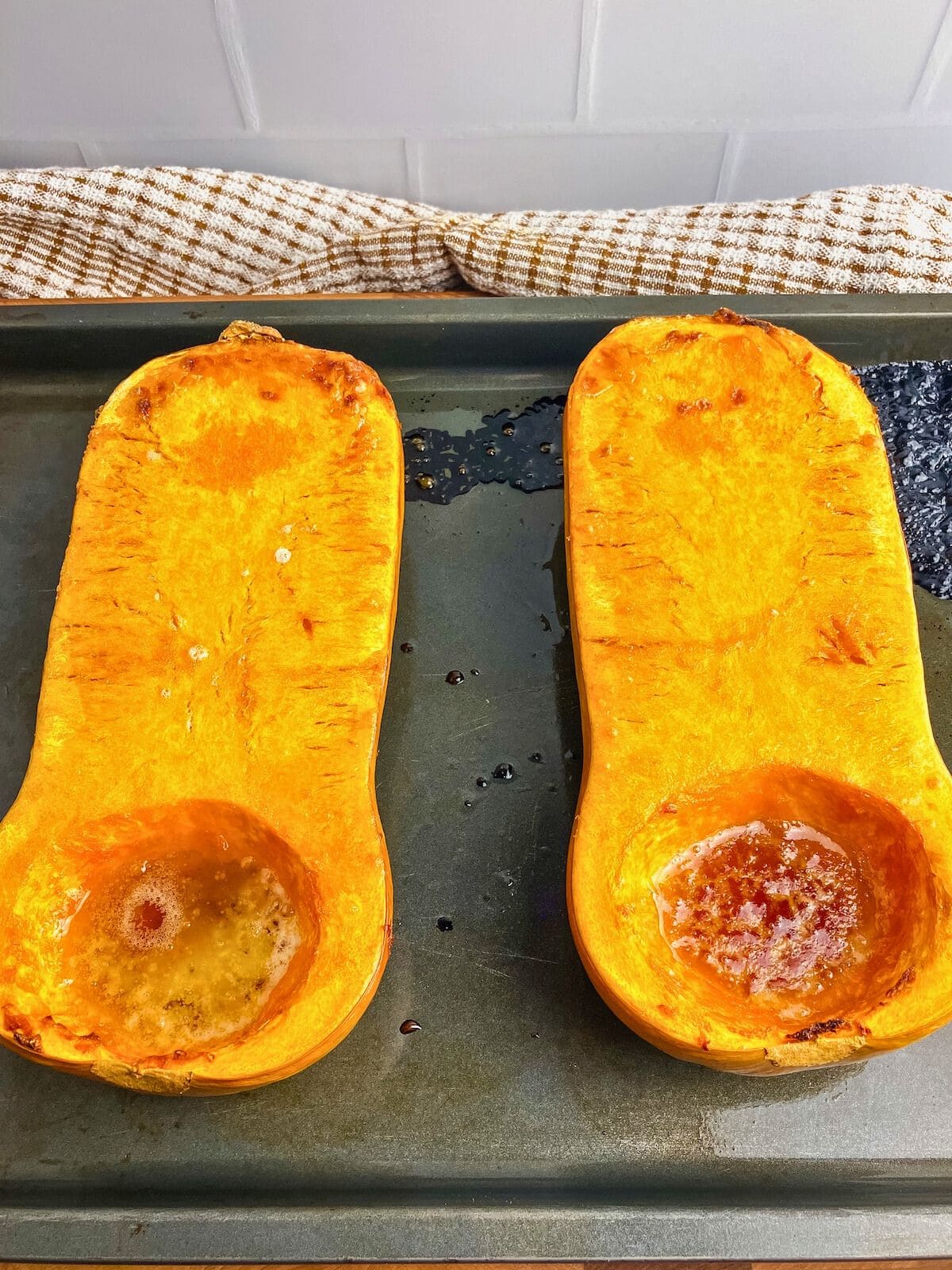 A butternut squash cut in half and roasted with butter and brown sugar nicely browned in the pan.
