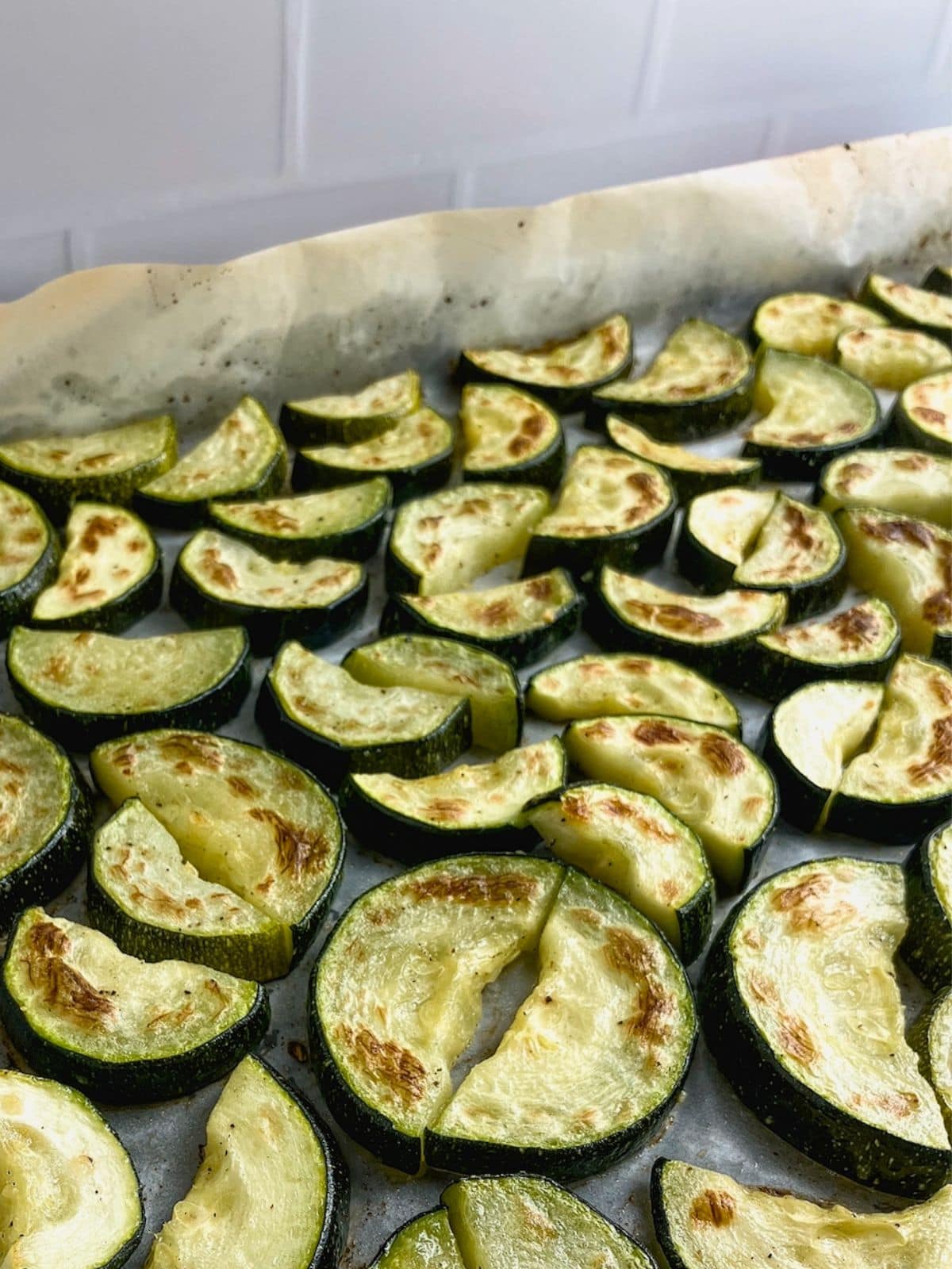 Roasted zucchini slices on a sheet pan.