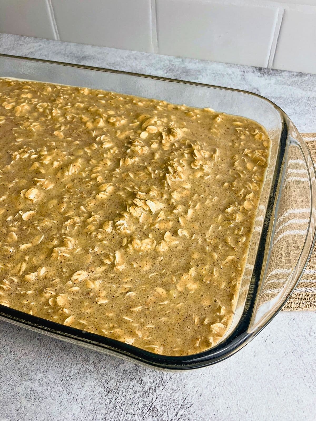 Pumpkin baked oatmeal batter poured into a 9x13-inch glass baking dish.