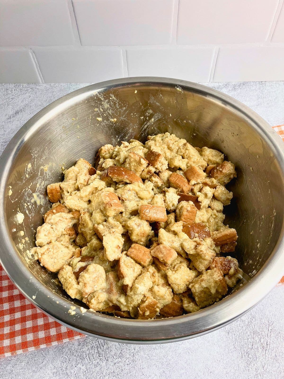 The egg mixture and bread cubes have been stirred together.