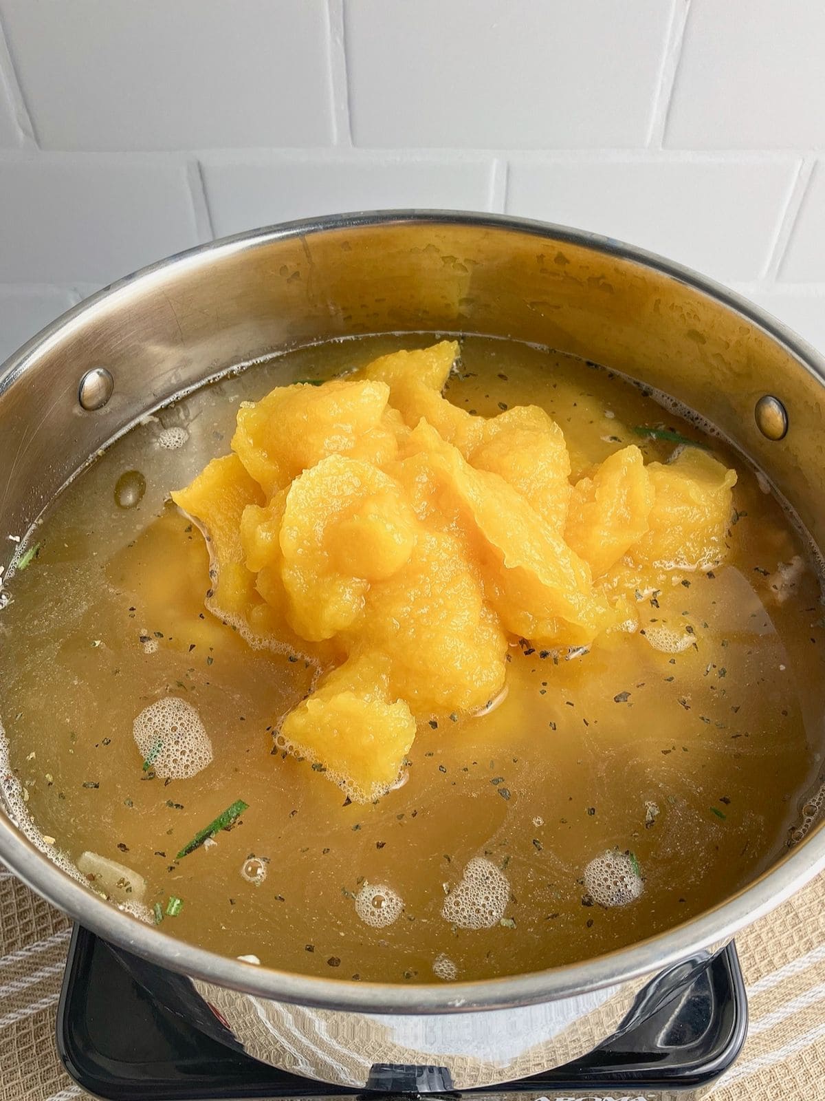 Turkey broth is added to the pumpkin puree and meat mixture.