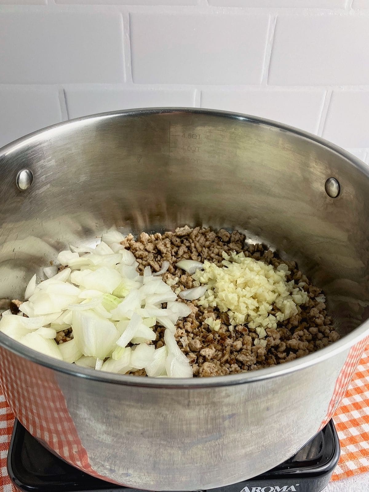 Browned ground beef with freshly chopped onions and garlic added.