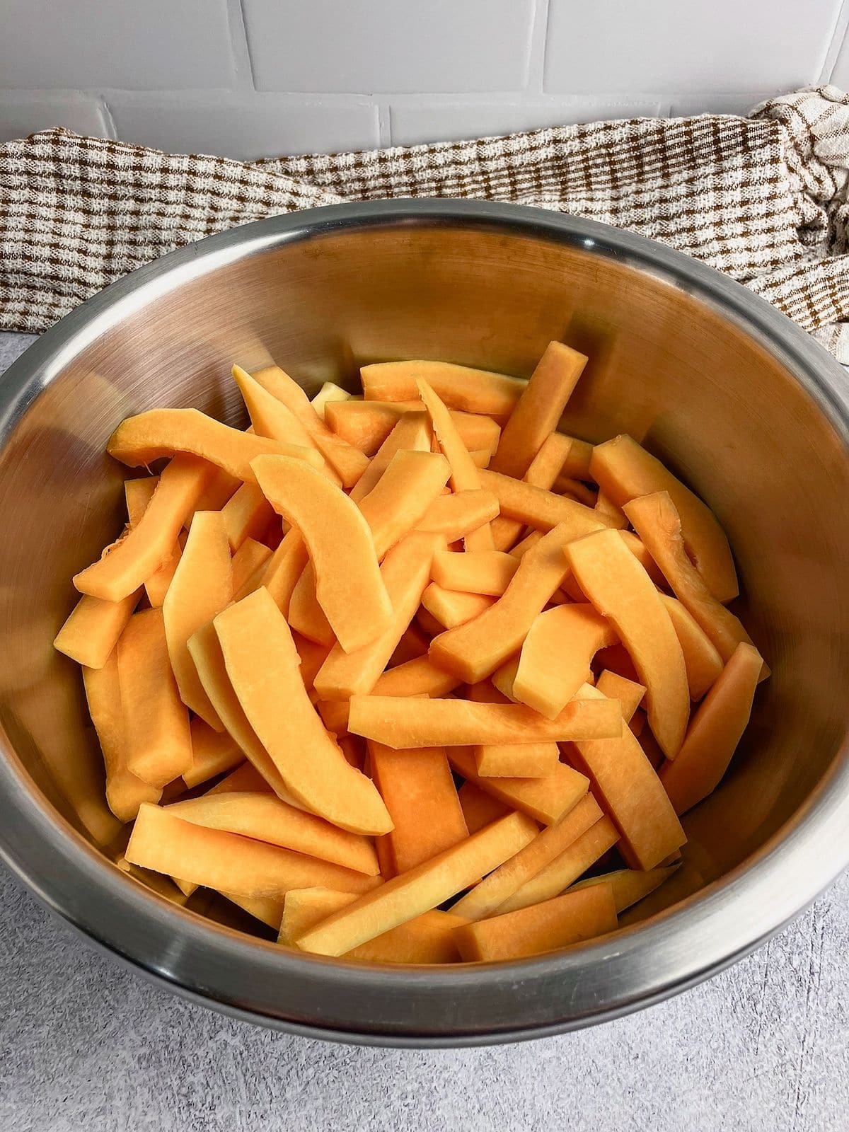 Sliced squash fries in a large mixing bowl.