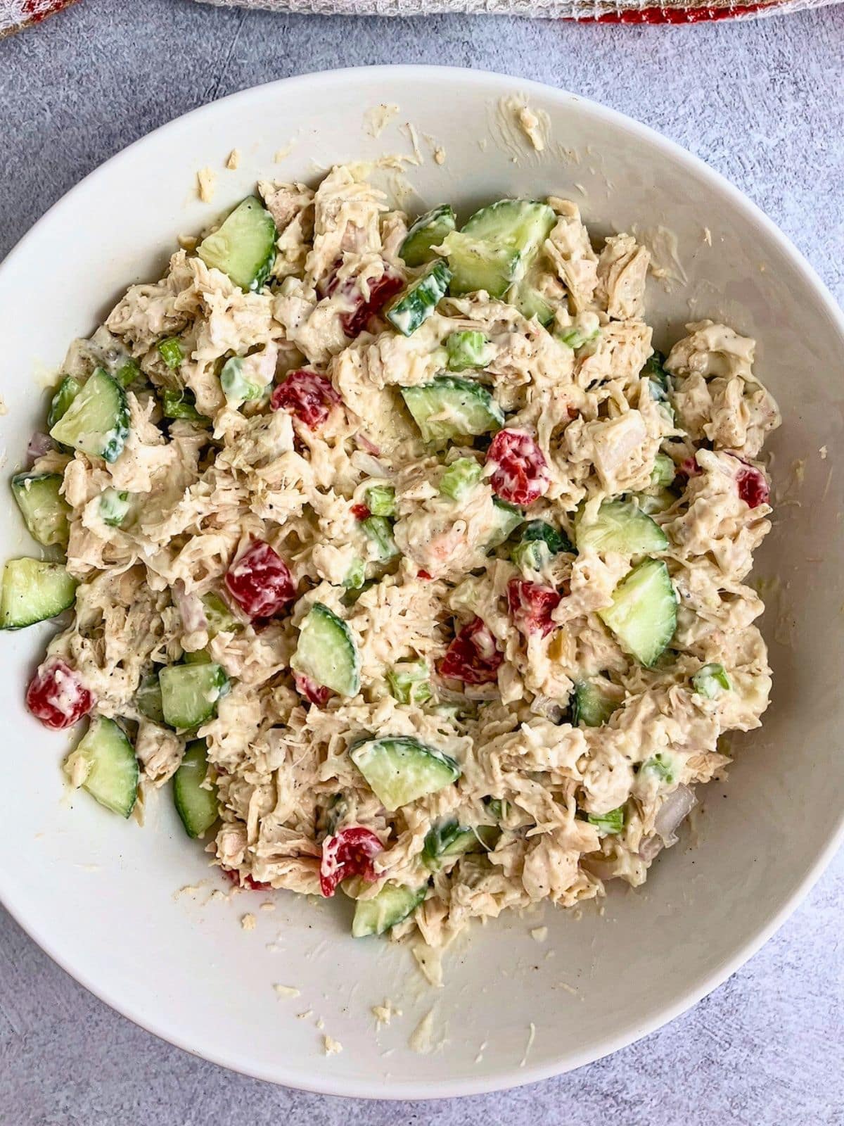 A white serving bowl filled with homemade chicken salad.