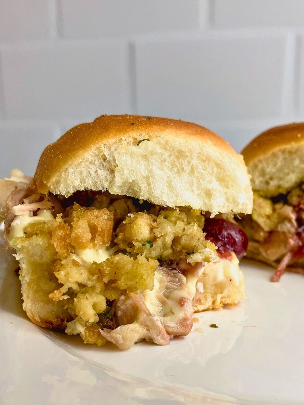 Homemade leftover turkey sliders on a white plate.