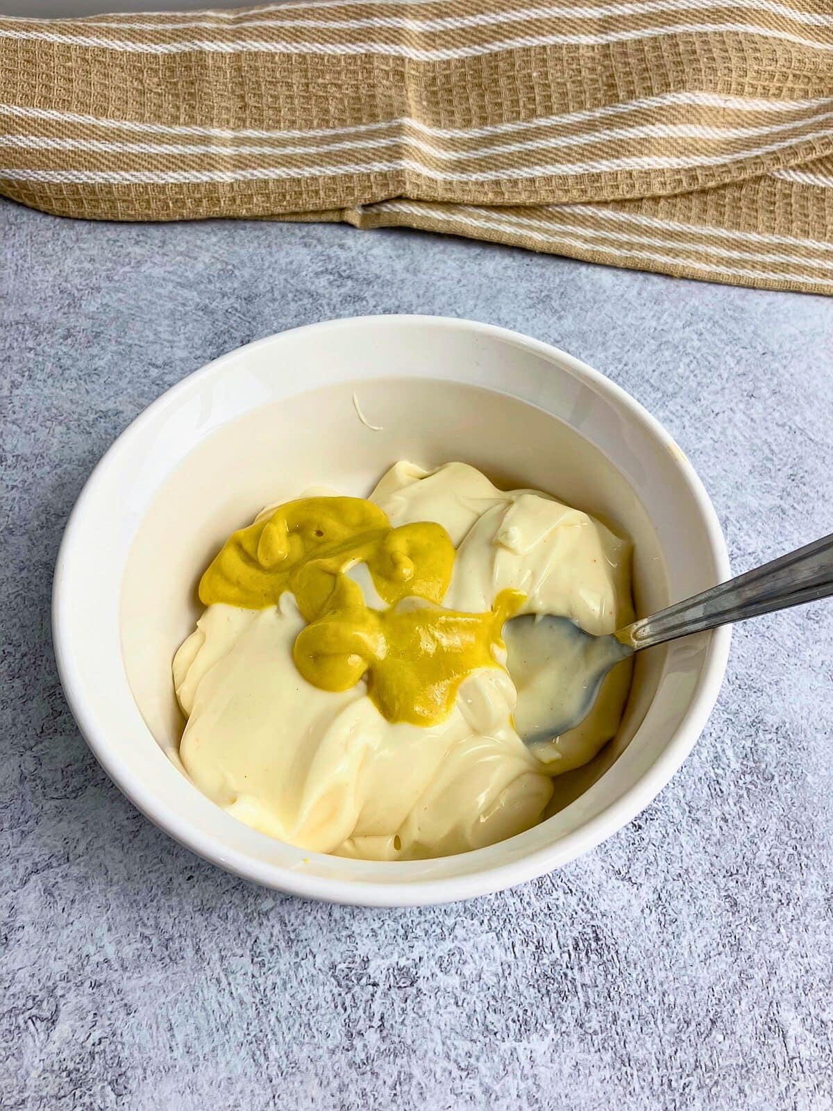 Miracle Whip and mustard in a small mixing bowl.