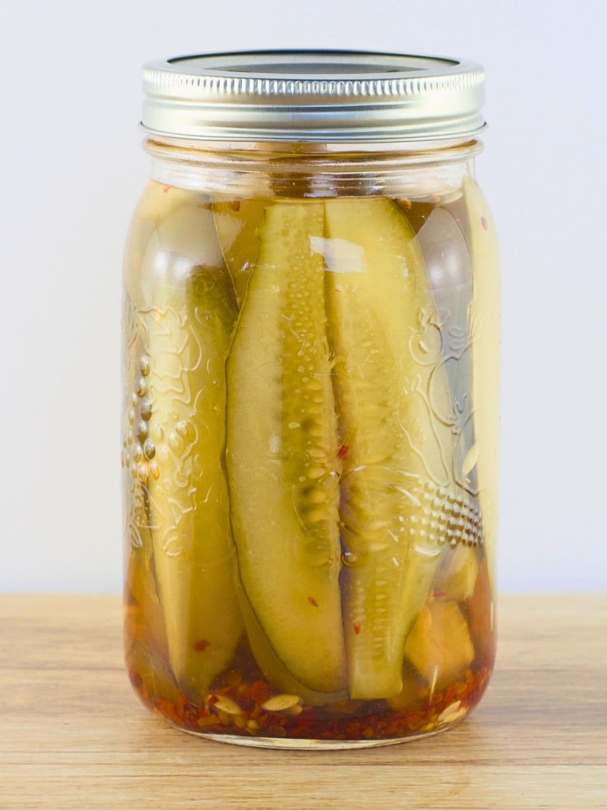 Hot pickling brine was poured over the cucumber slices, and the lid was added.