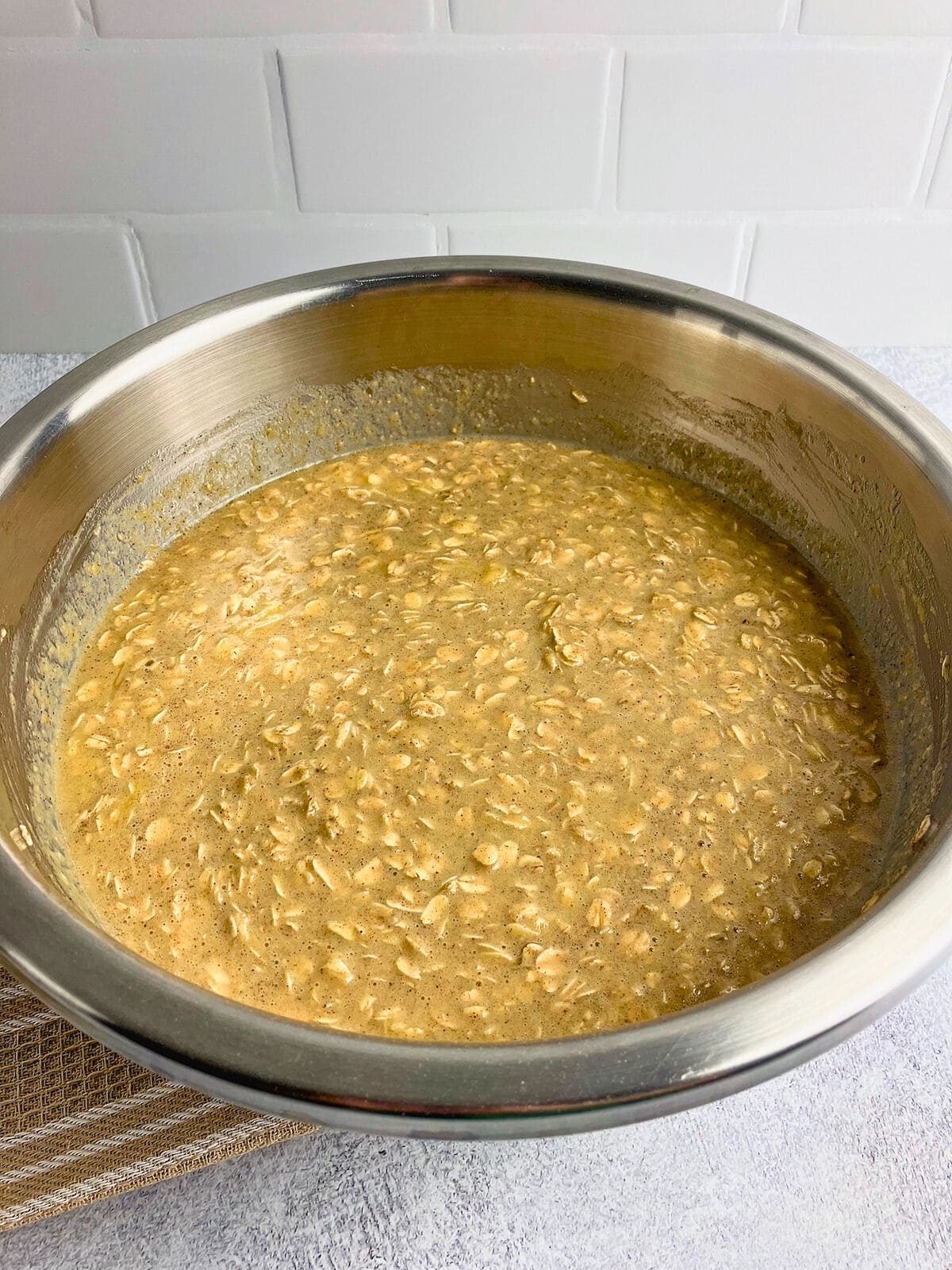 Pumpkin puree is mixed into the batter in a large mixing bowl.