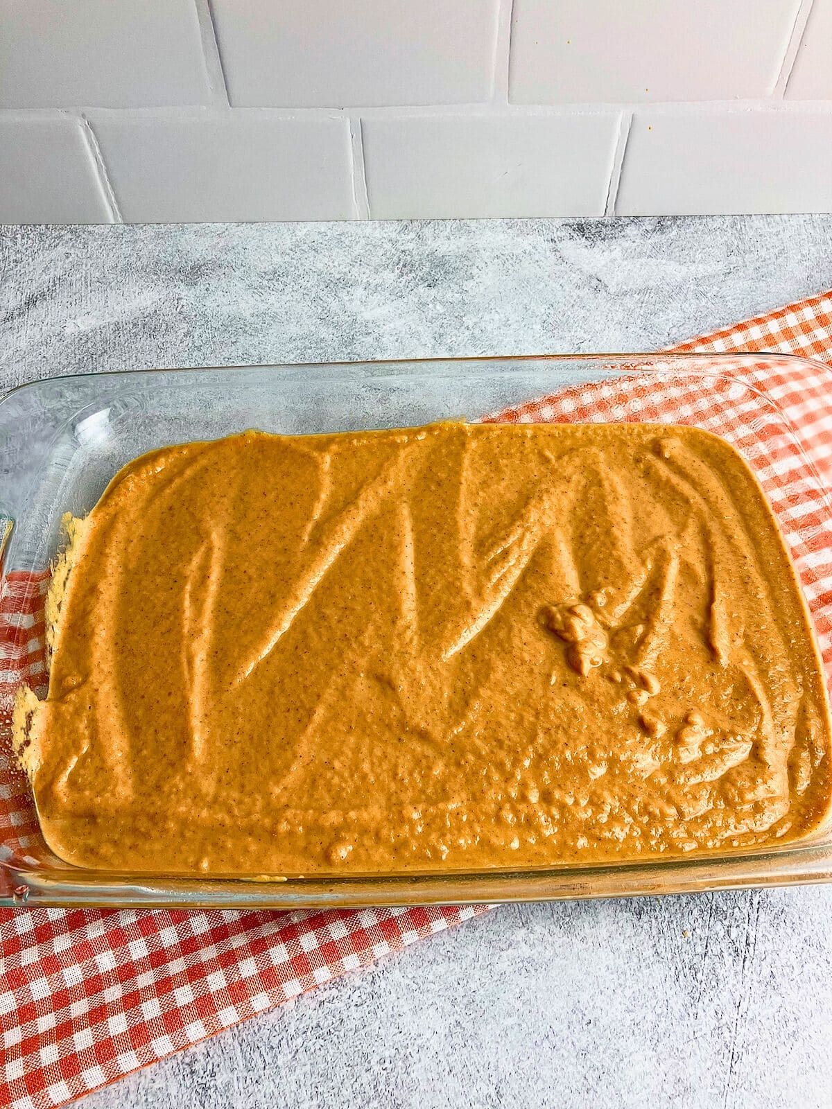 Pumpkin filling is poured into a 9x13-inch baking dish.