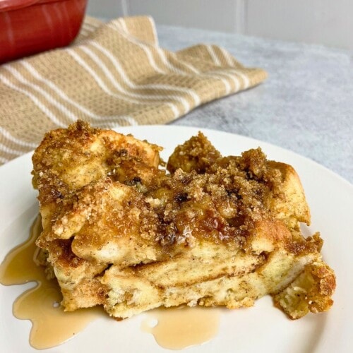 French toast pumpkin casserole with a brown sugar topping on a plate and drizzled with maple syrup.