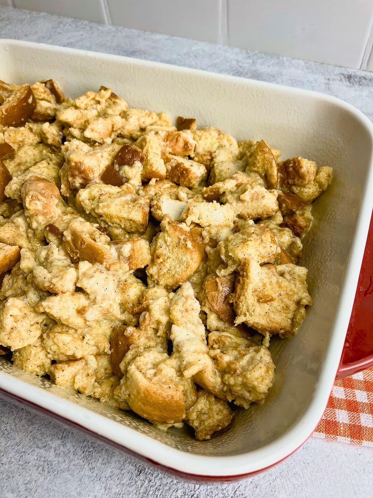 Egg and bread mixture spread into a baking dish.