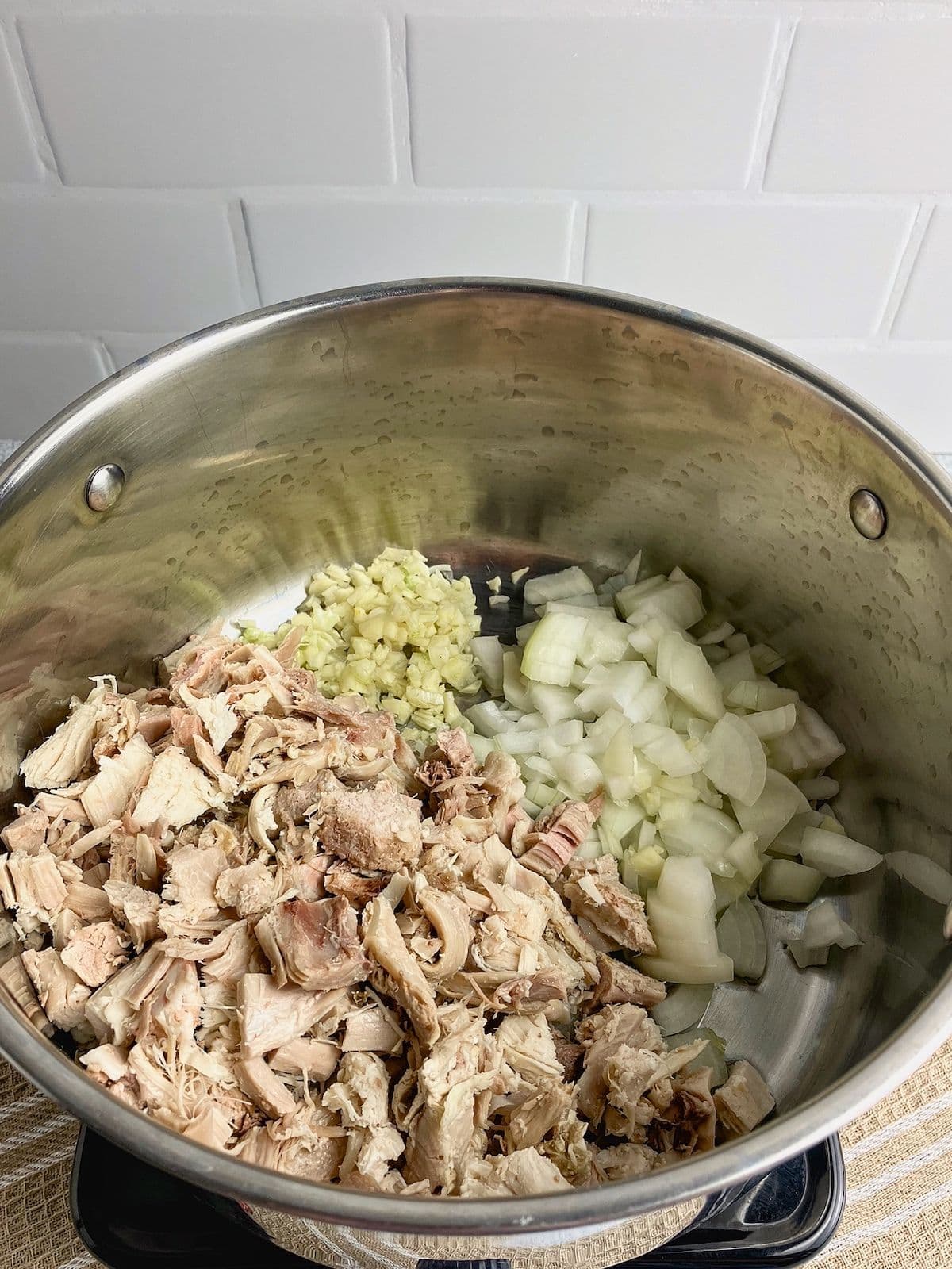 Cooked diced turkey, onions, and garlic in a large pot.
