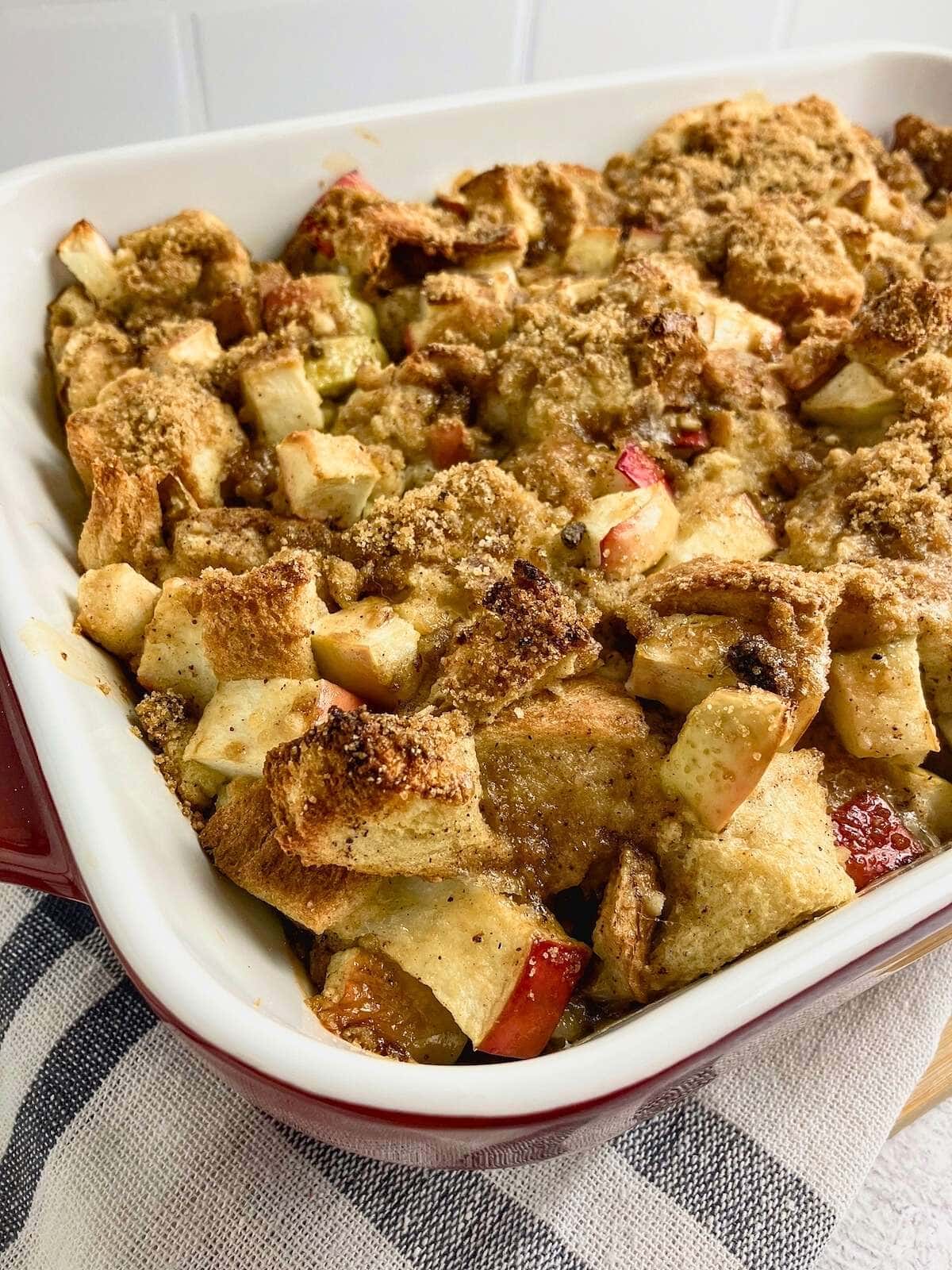Apple cinnamon French toast casserole in a red and white baking dish.
