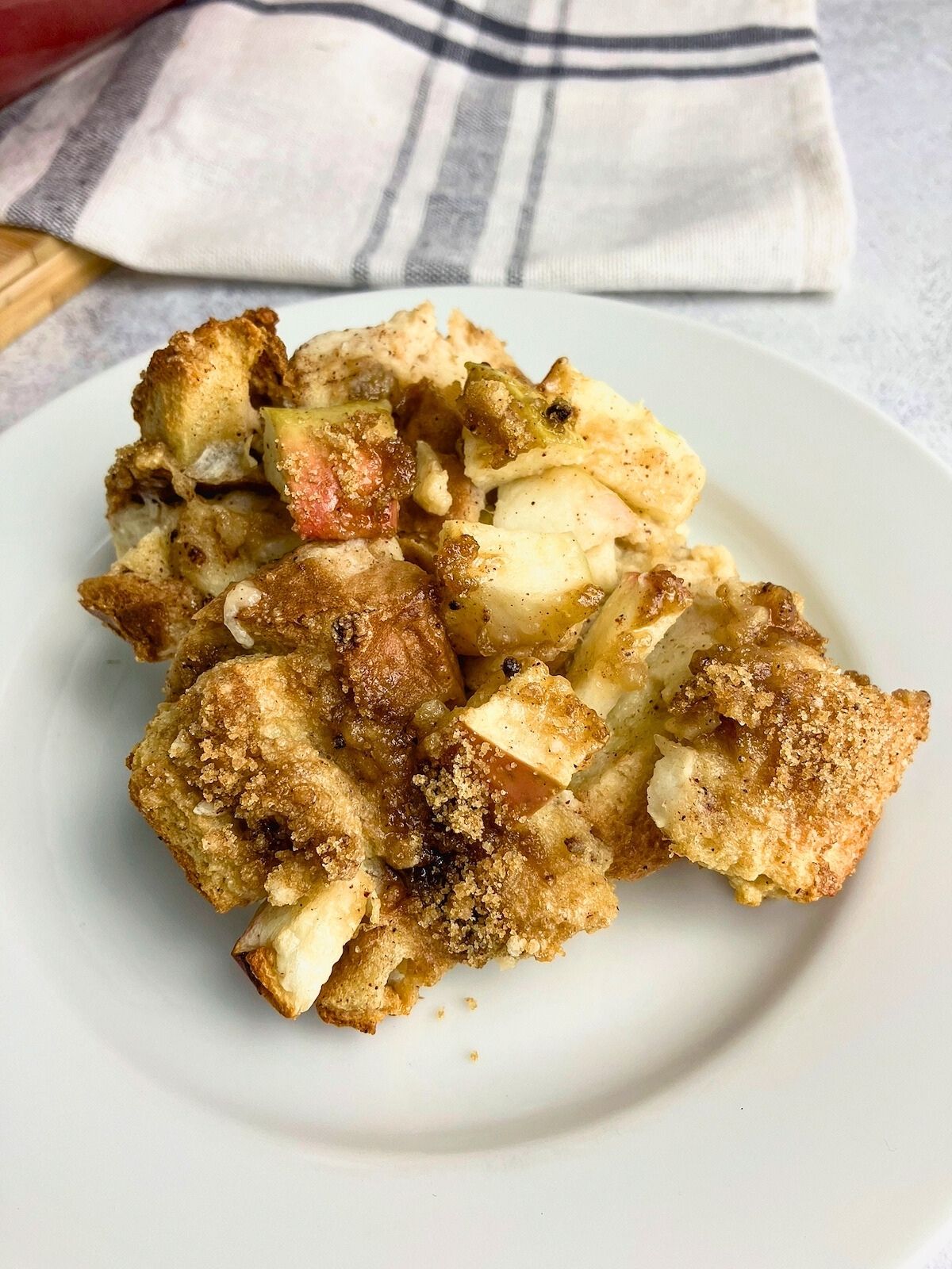 A slice of apple cinnamon French toast casserole on a white plate.