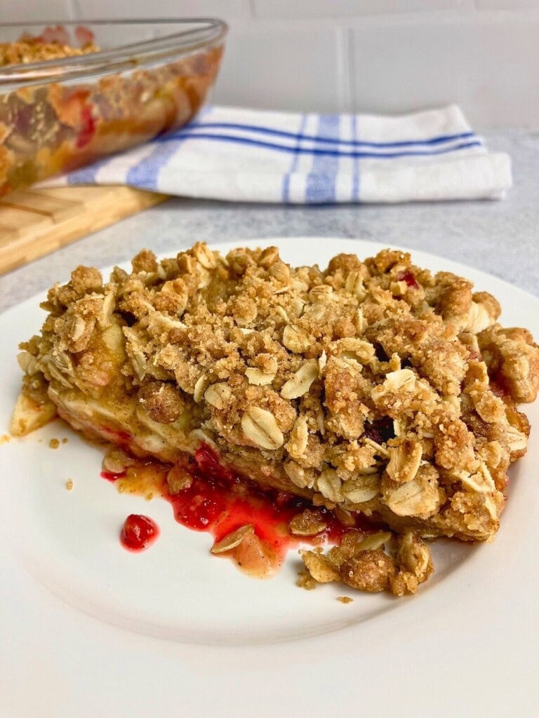 Homemade apple cranberry pumpkin crisp on a white plate.