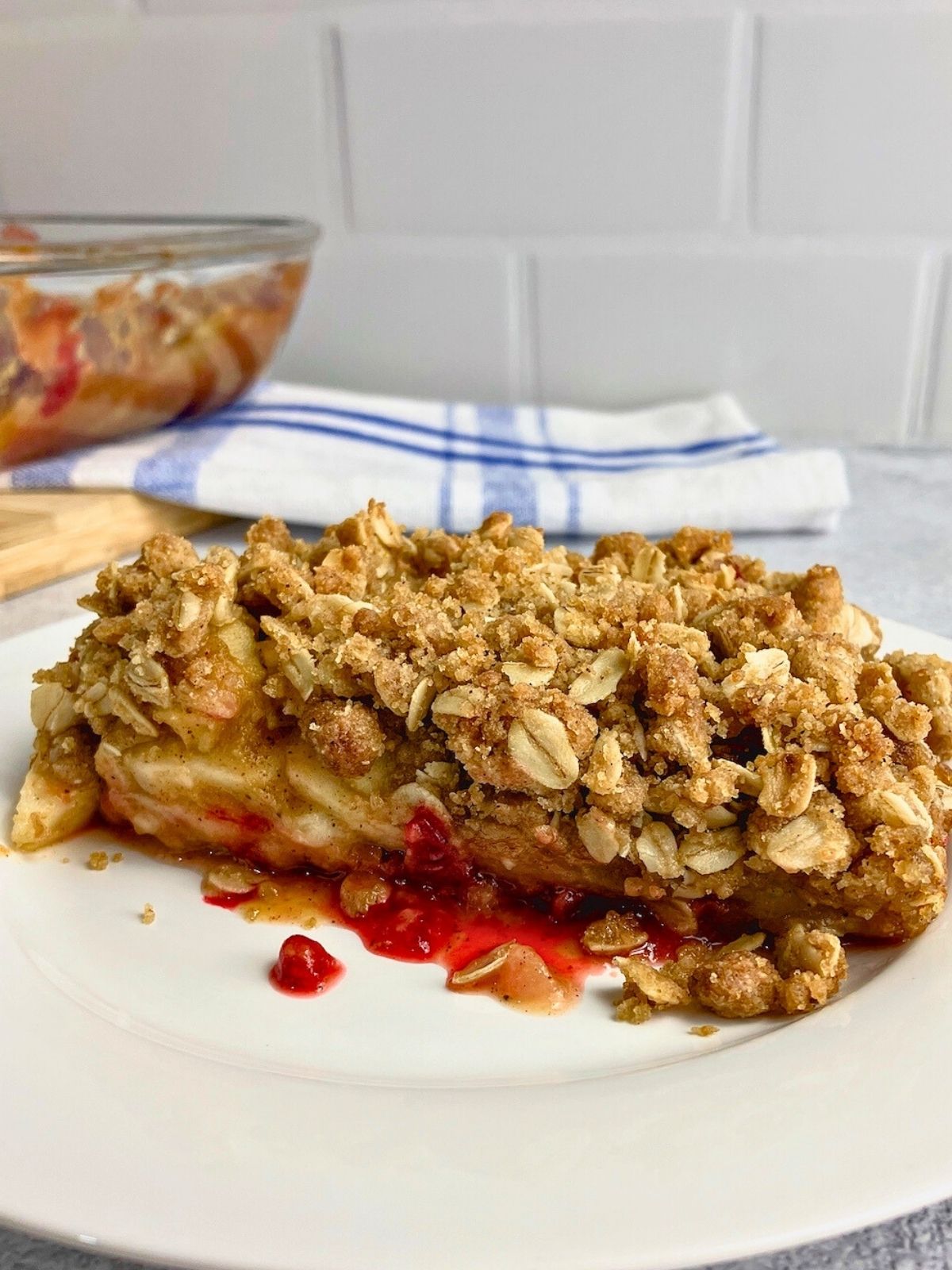 Homemade apple cranberry pumpkin crisp on a white plate.