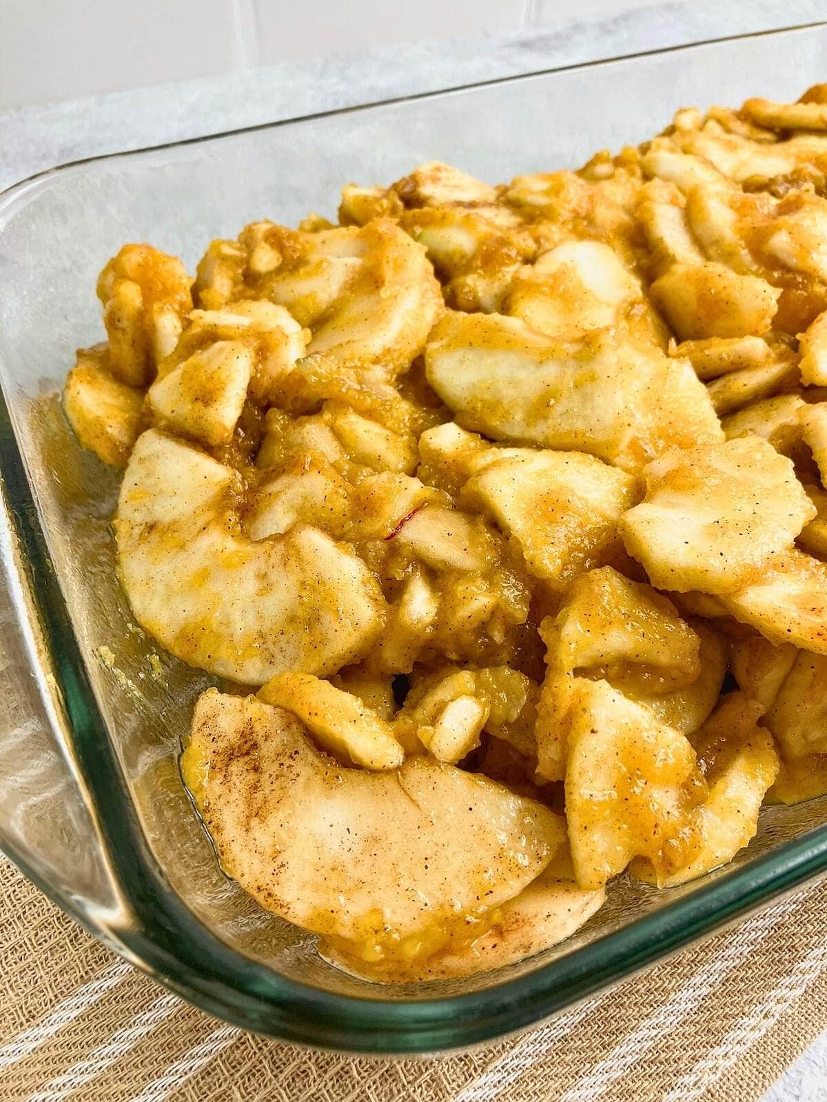 The apple pumpkin crisp filling has been spread into a 9x13 inch glass baking dish.