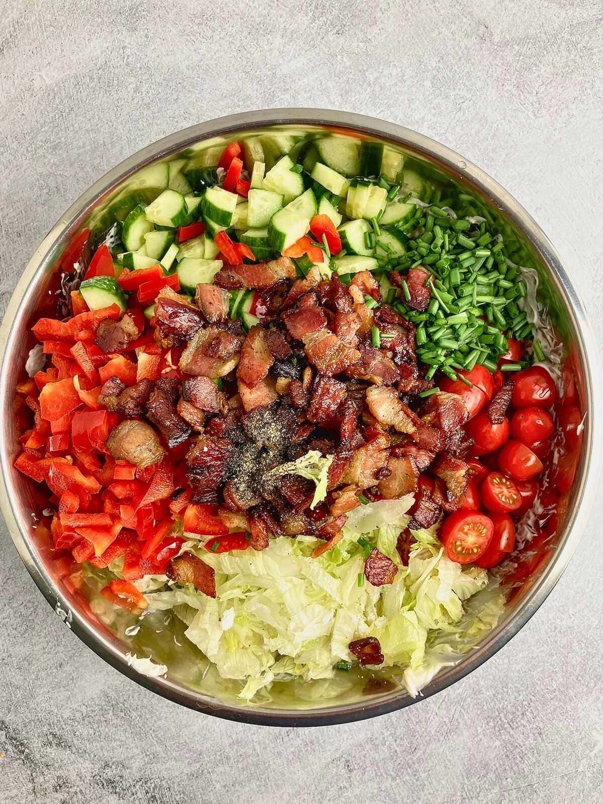 Cooked bacon pieces, veggies, and seasonings were added on top of the pasta.