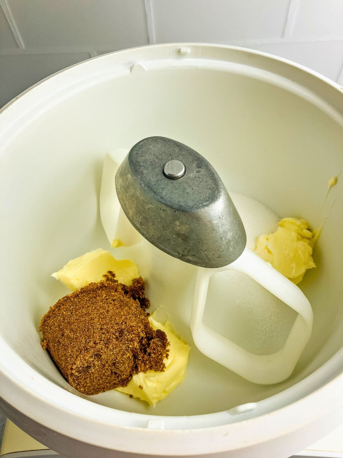 Butter, brown sugar, and white sugar in a stand mixer bowl.
