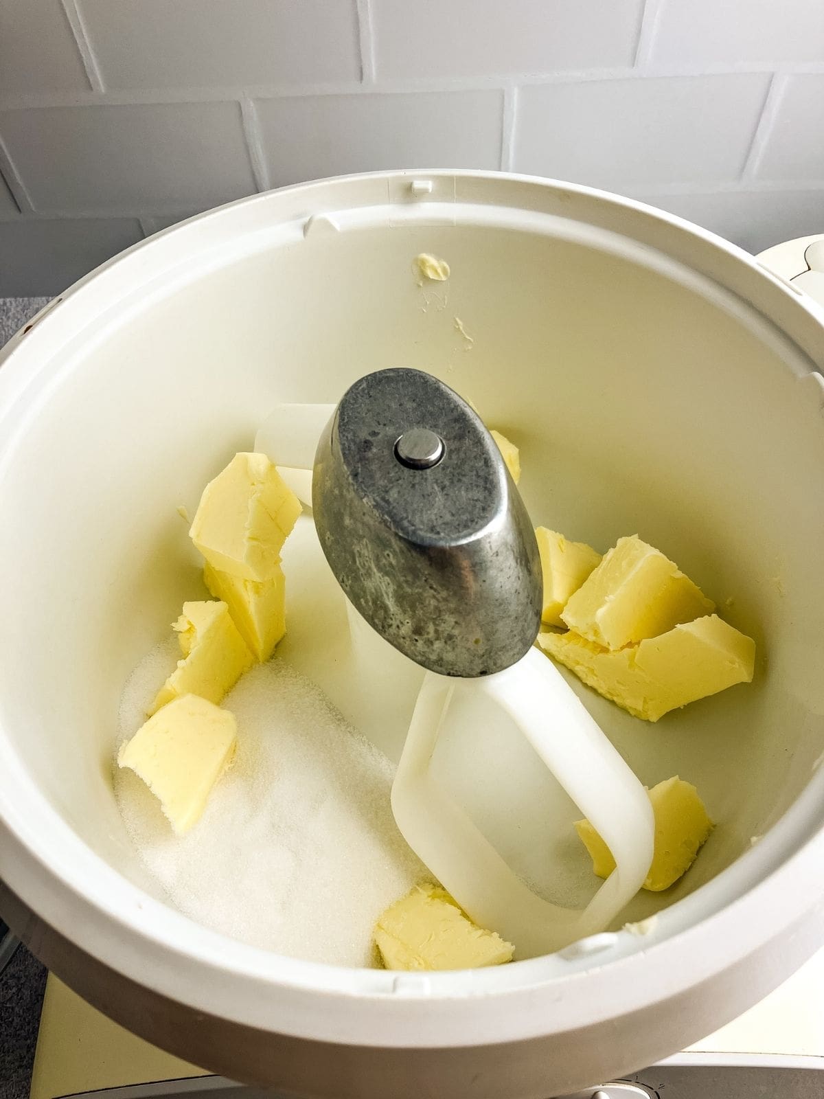 White sugar and butter in a stand mixer bowl.