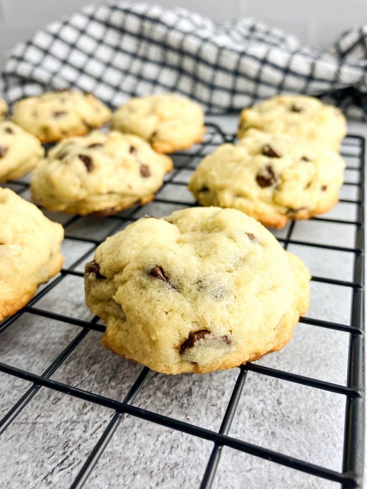Thick chocolate chip cookies are cooling on a wire rack.