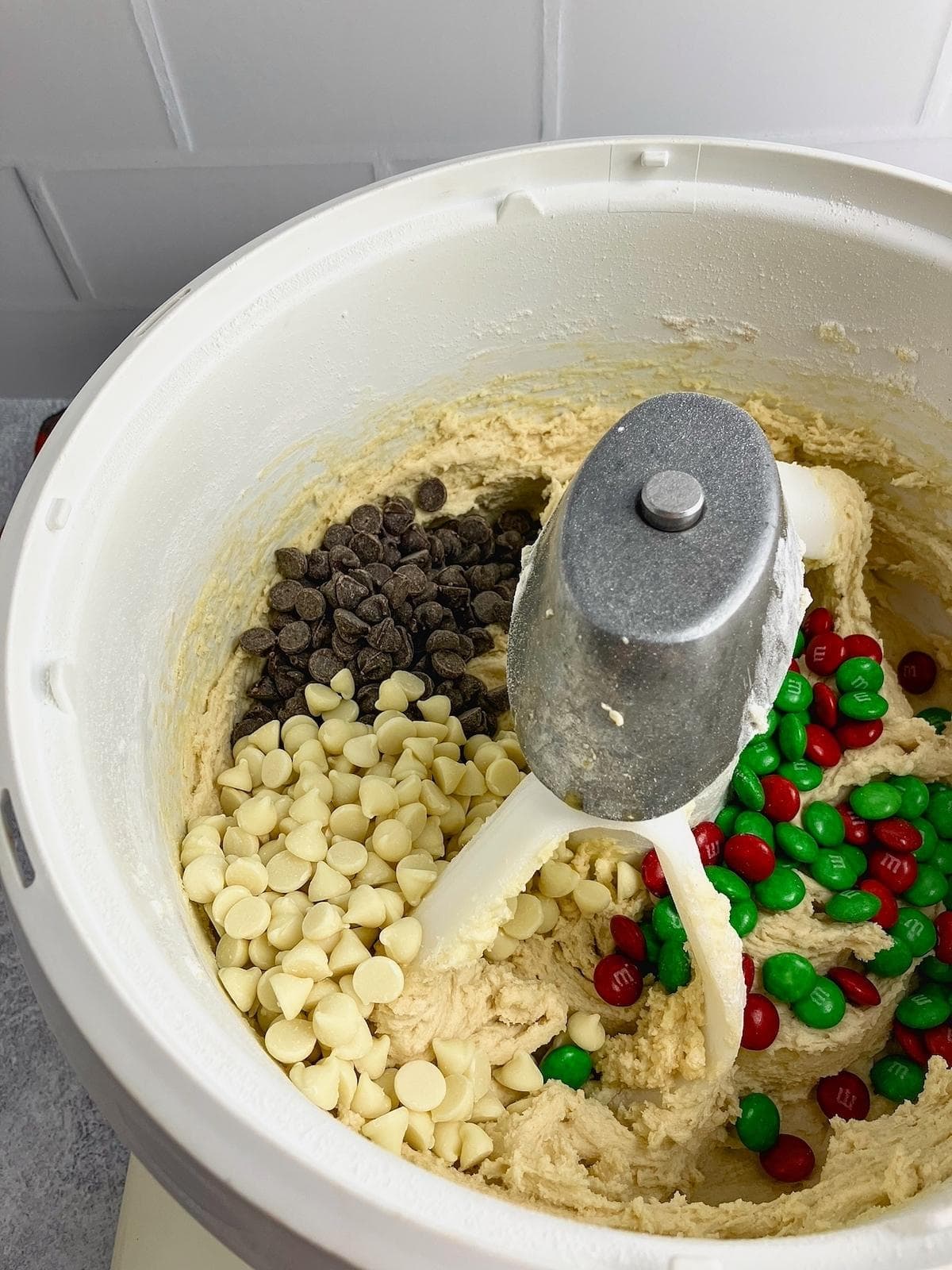 Chocolate chips, white chocolate chips, and M&Ms were added to the mixing bowl.