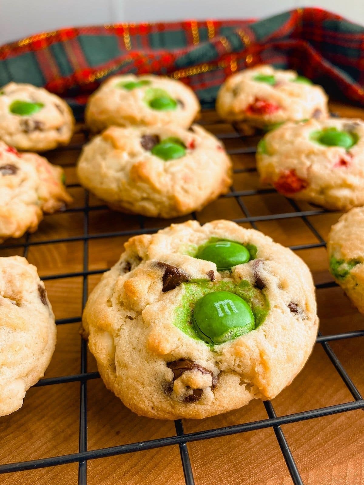 M&M chocolate chip cookies are cooling on a rack.