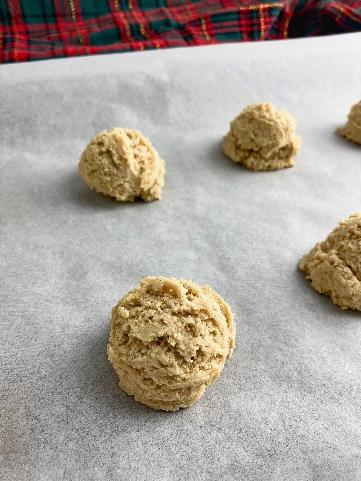 Peanut butter cookie dough balls on a baking sheet.