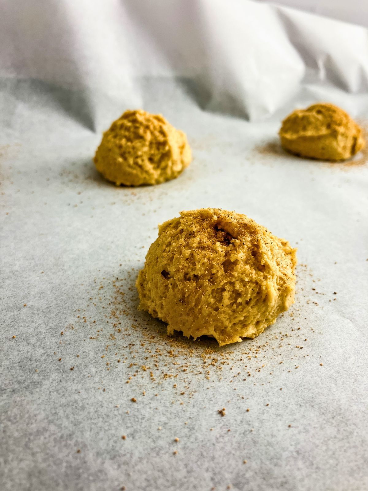 Ground nutmeg sprinkled over the cookie dough balls.
