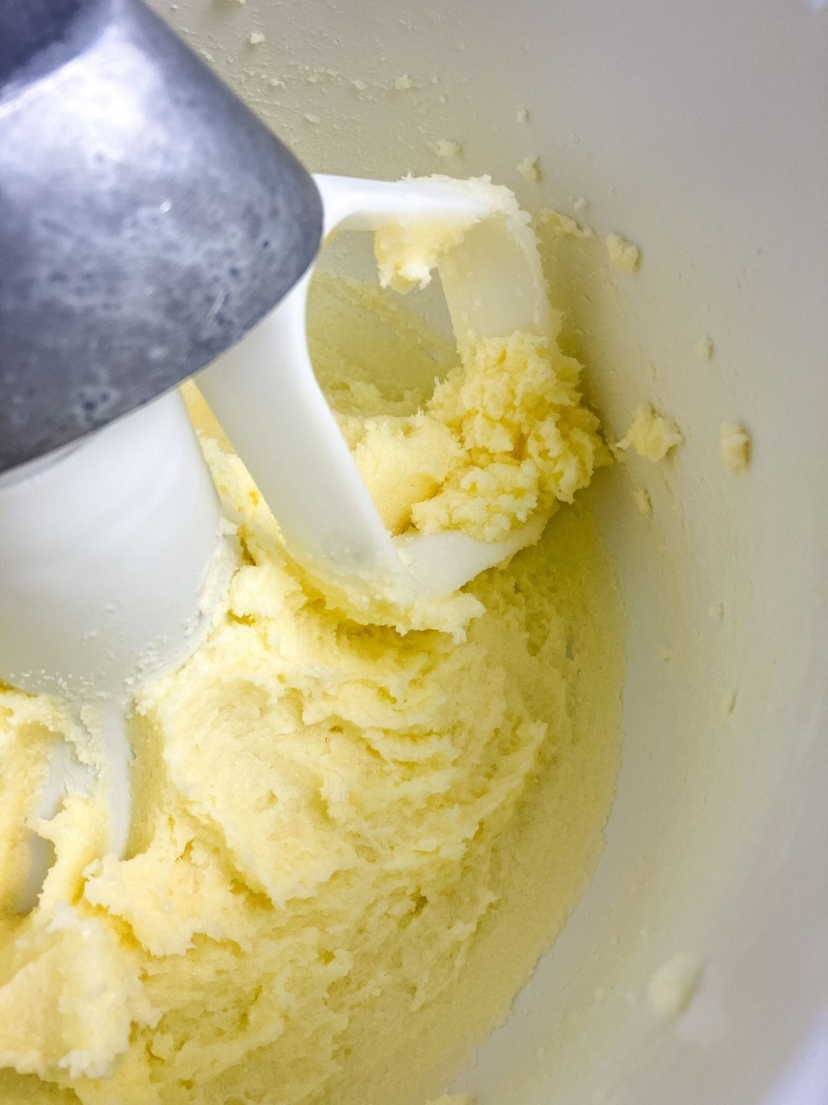 Butter and sugar are creamed together in a mixer bowl.