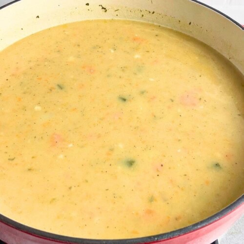 Creamy potato vegetable soup in a large red dutch oven.