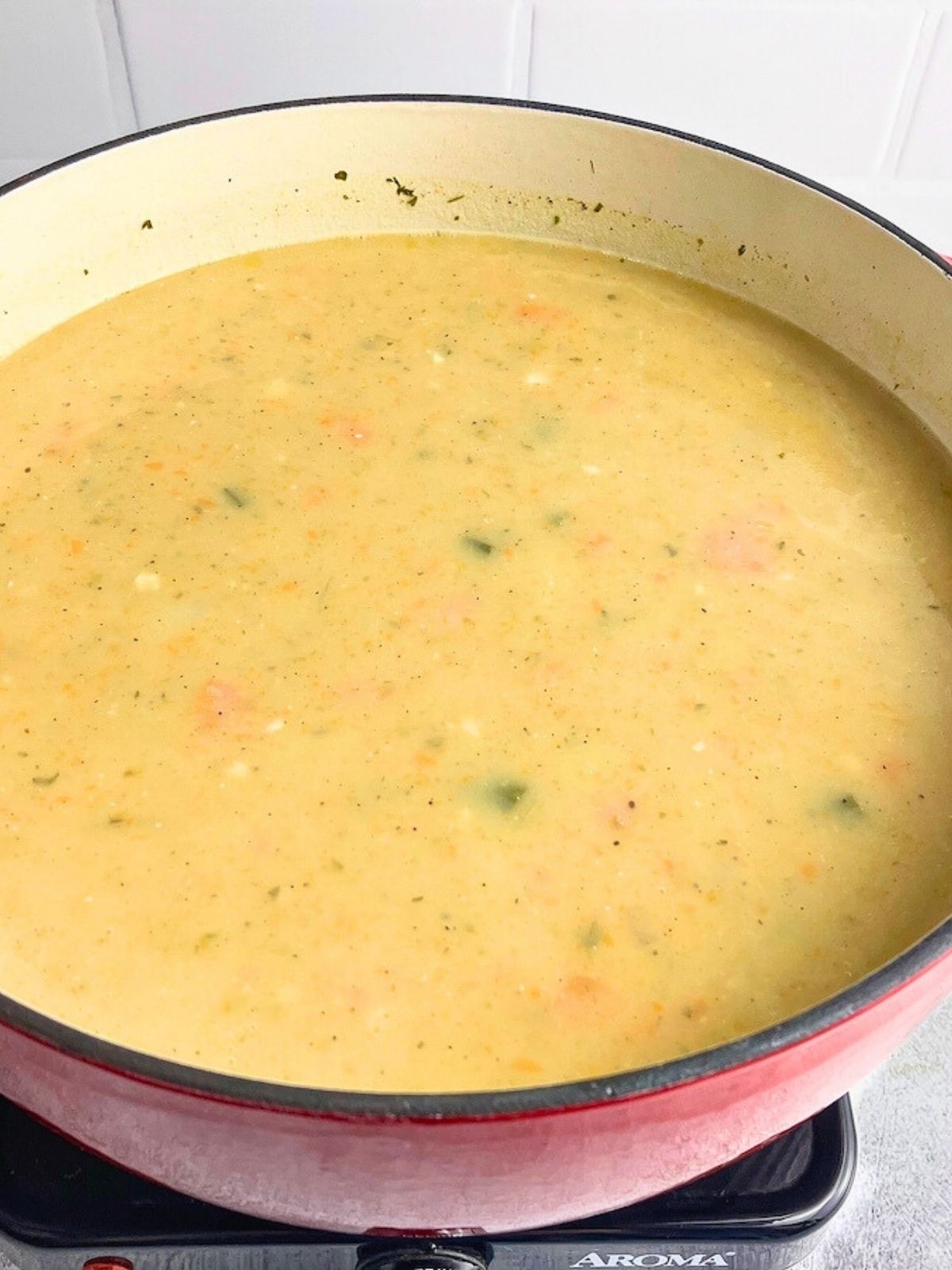 Creamy potato vegetable soup in a large red dutch oven.