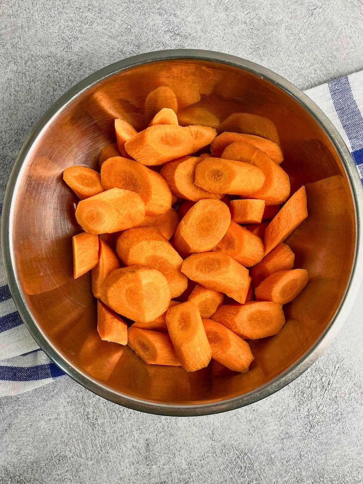 Sliced carrots in a large mixing bowl.