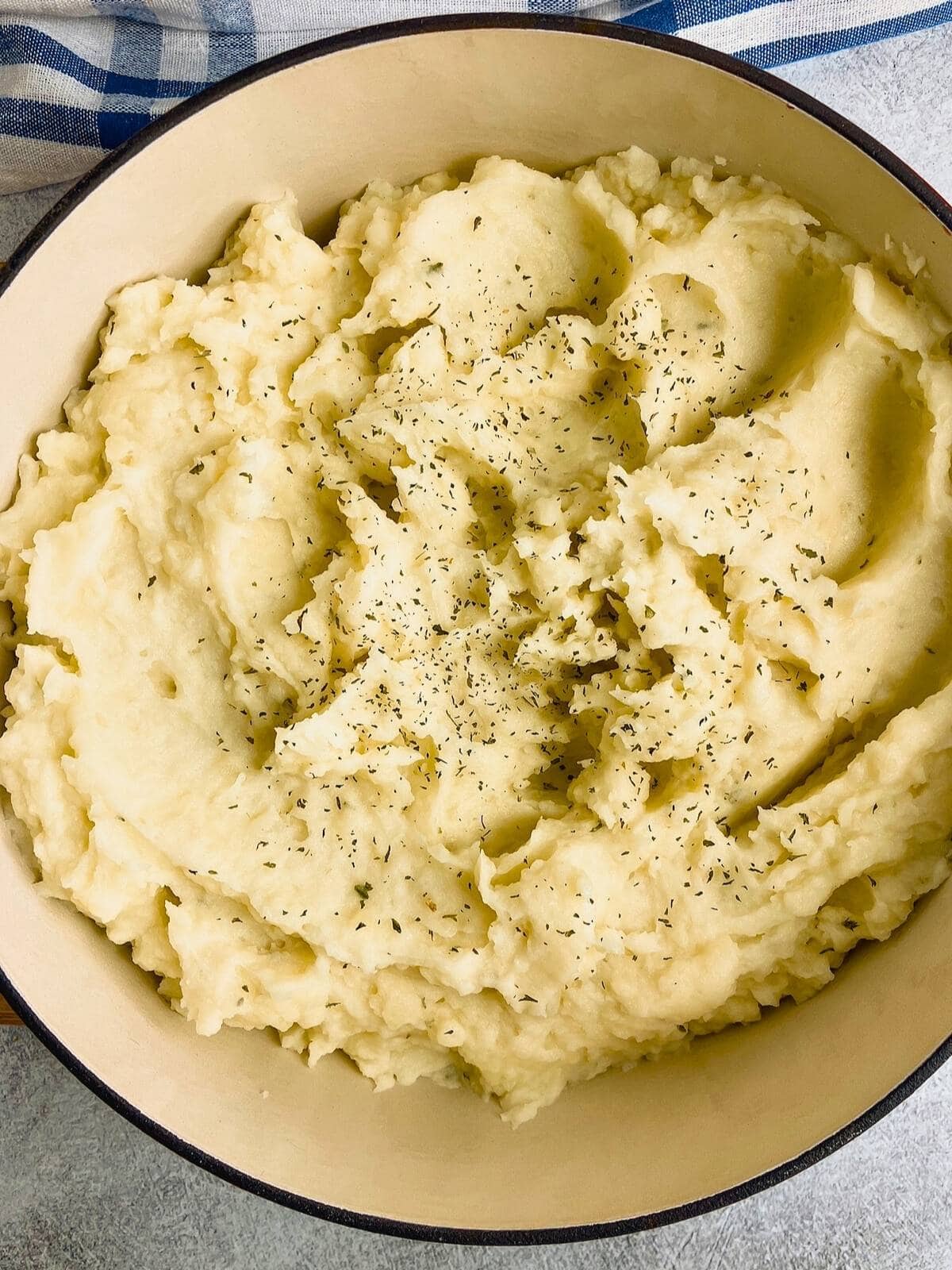 Easy homemade mashed potatoes in a large pot topped with parsley.