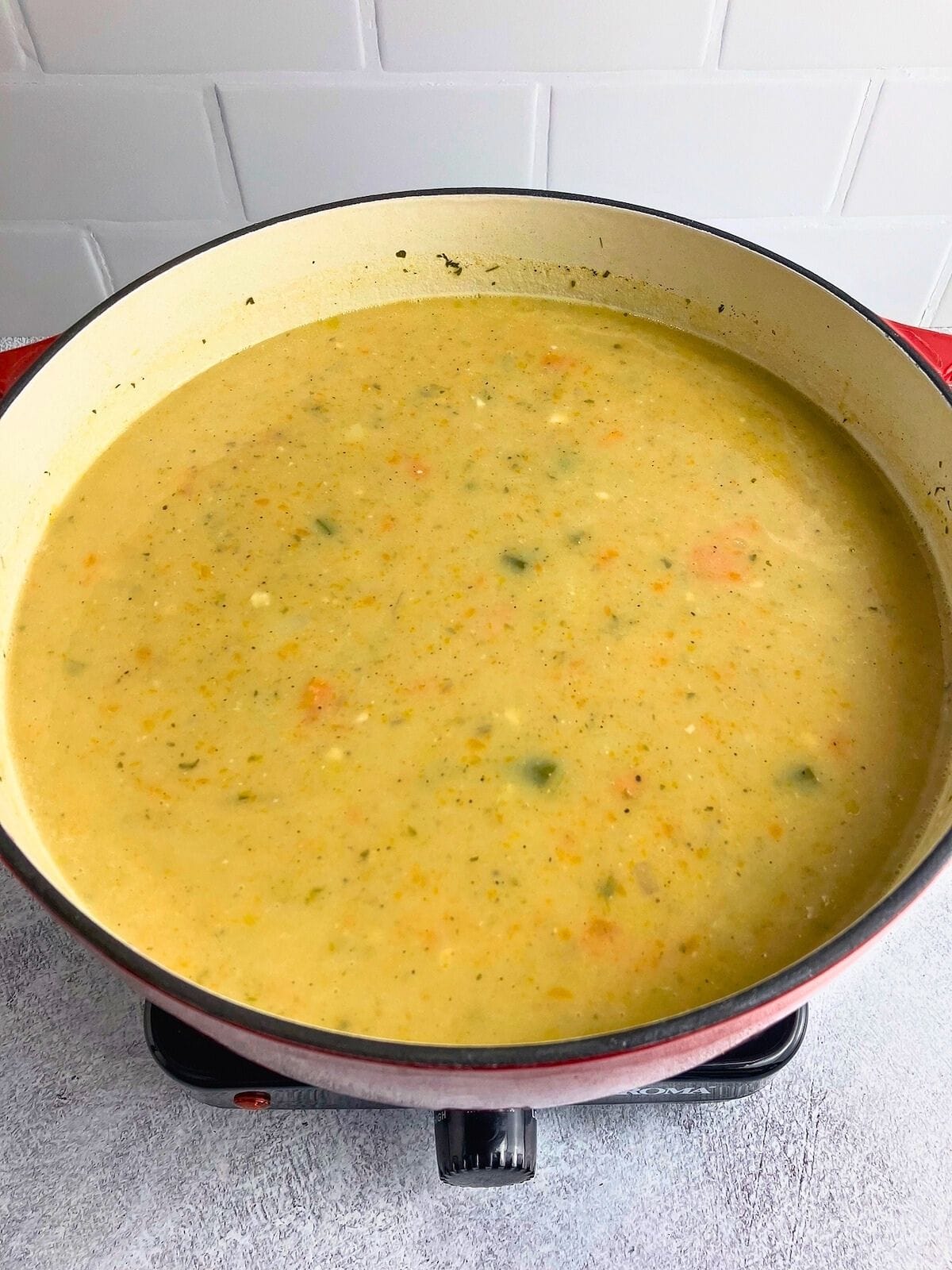 Homemade potato vegetable soup in a large red dutch oven.