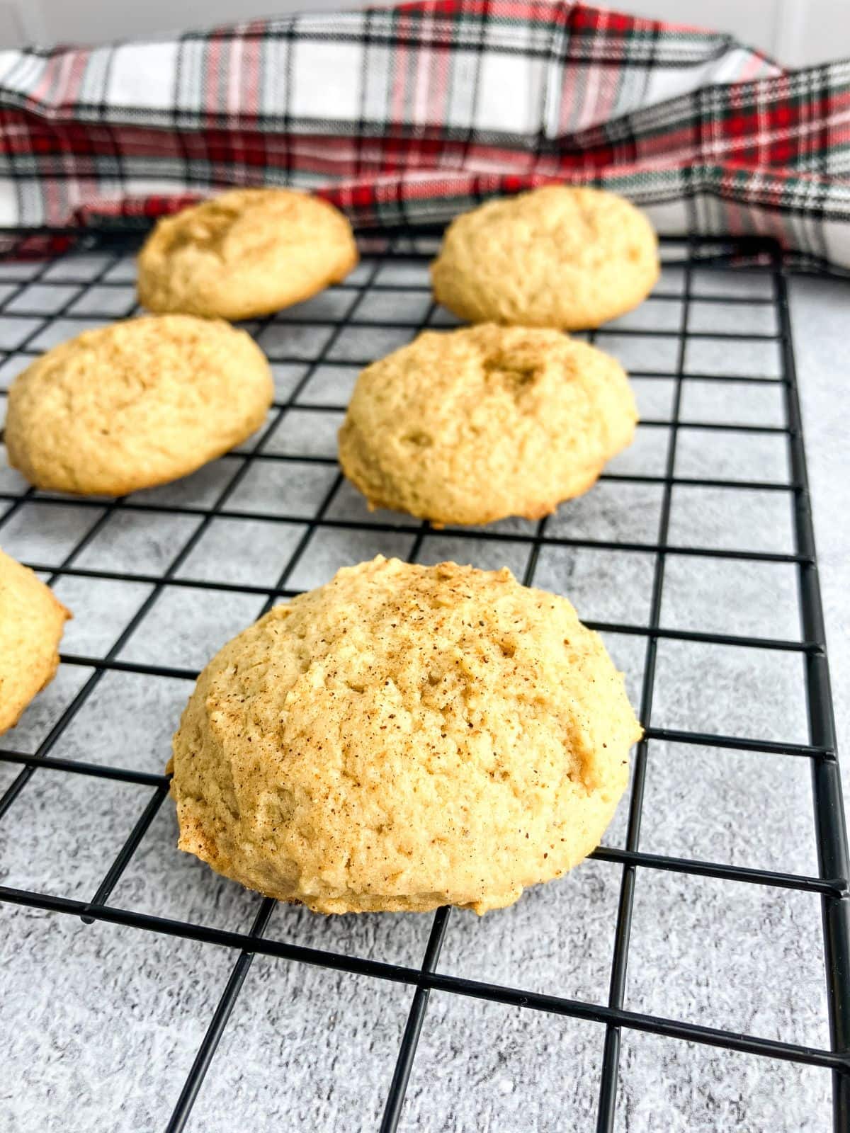 Eggnog cookies are cooling on a wire rack.