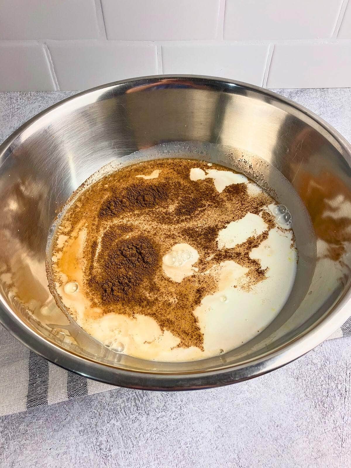 Eggs, milk, and spices in a large mixing bowl.