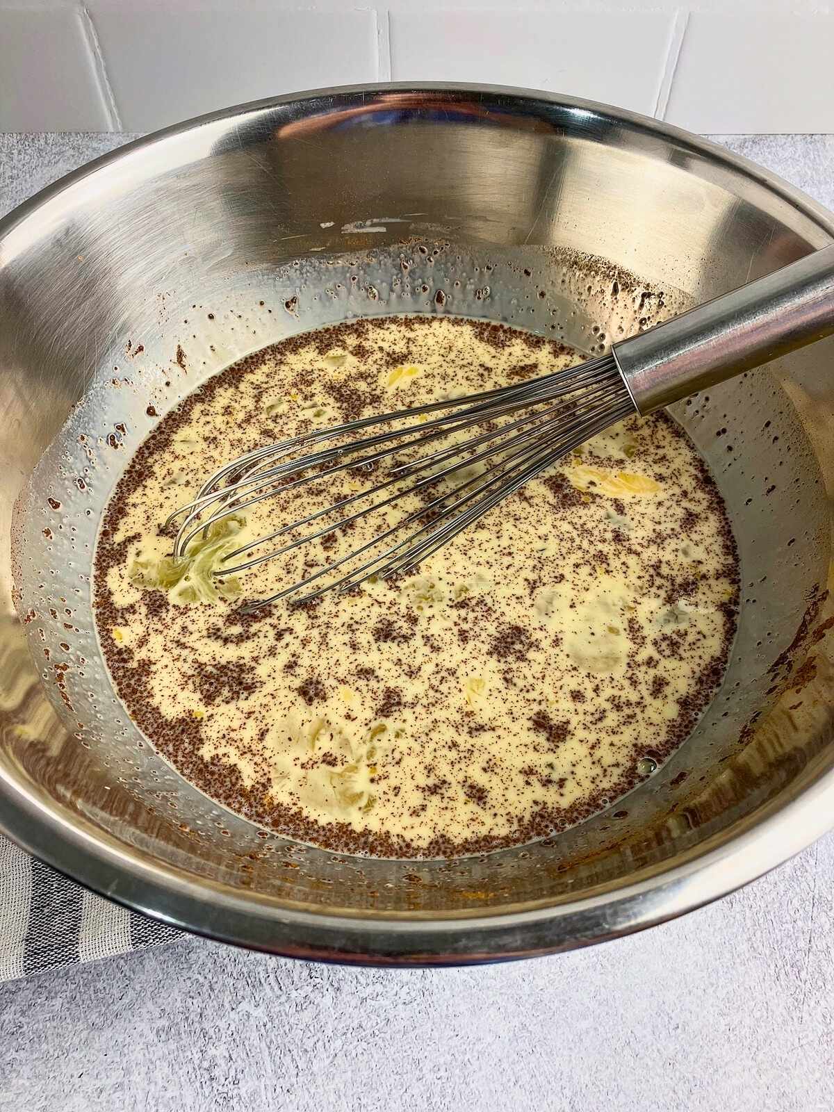 Eggs, milk, and spices are mixed together in a large mixing bowl.