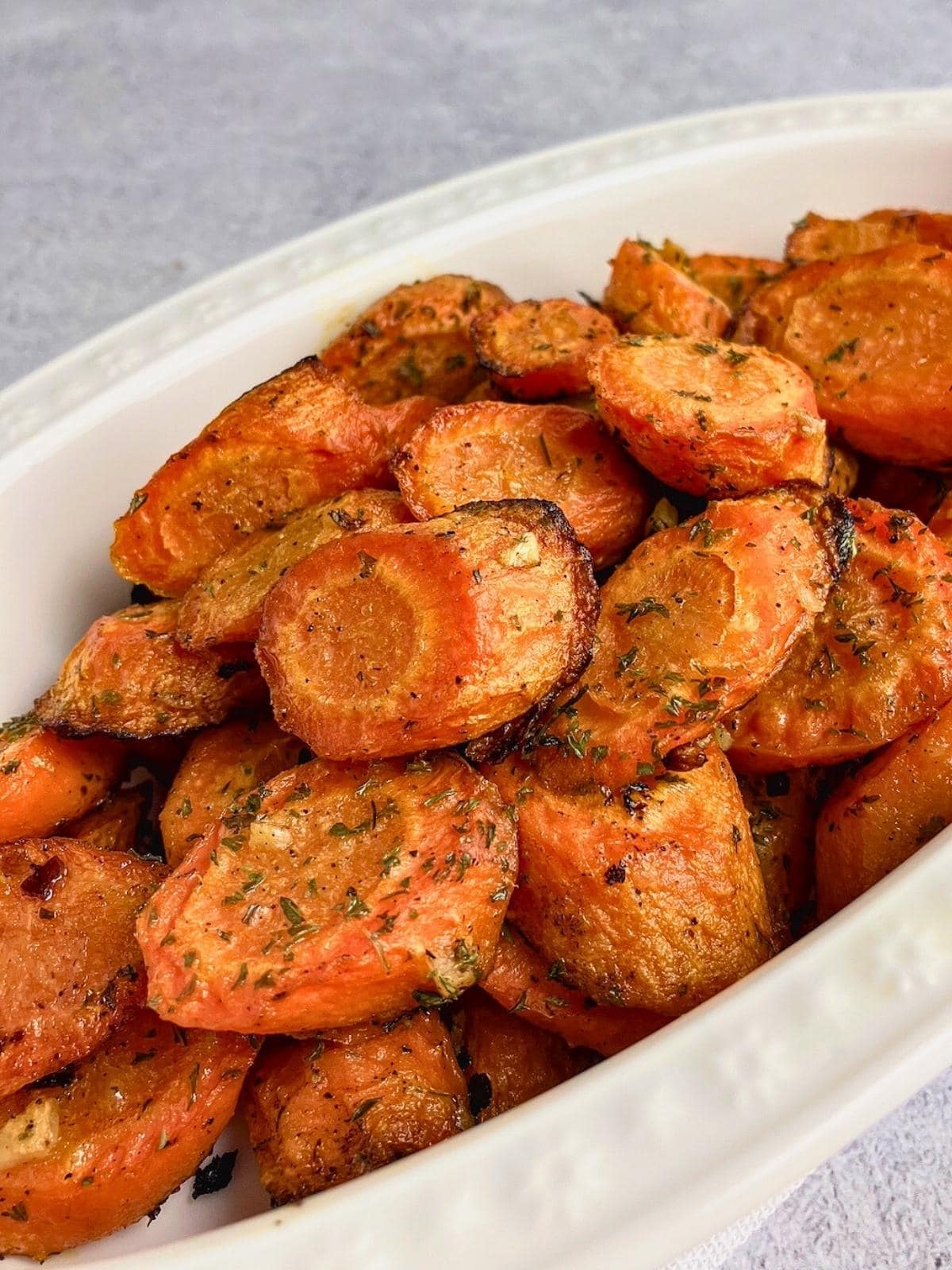 Easy garlic roasted carrots sliced in a serving dish.