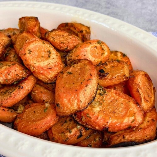 Easy garlic roasted carrots sliced in a serving dish.