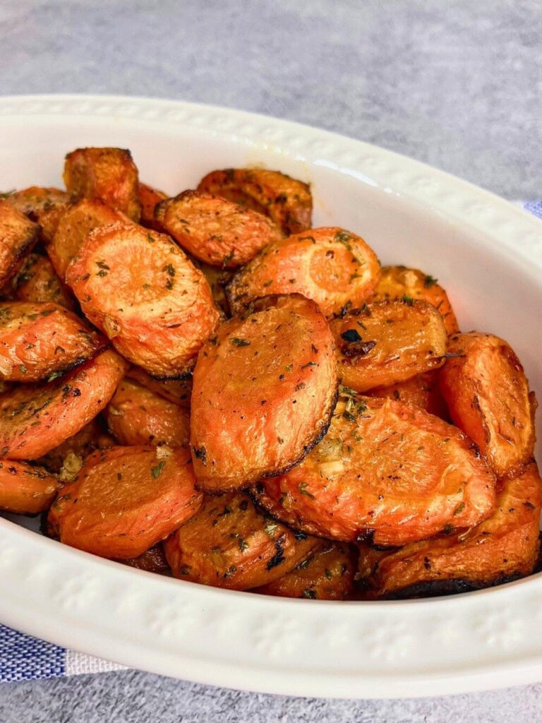 Easy garlic roasted carrots sliced in a serving dish.