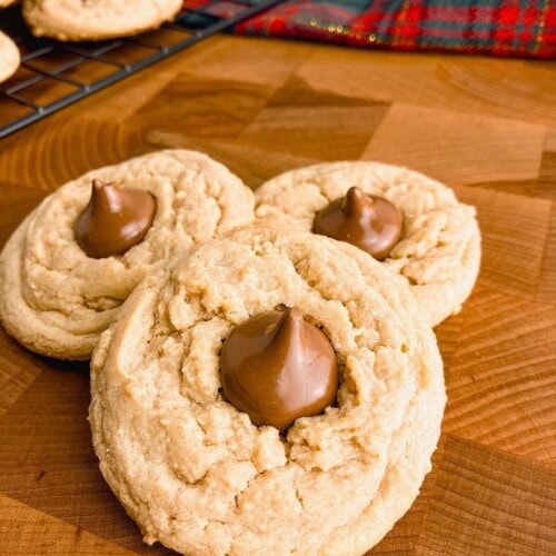Homemade peanut butter blossoms on a wooden table.