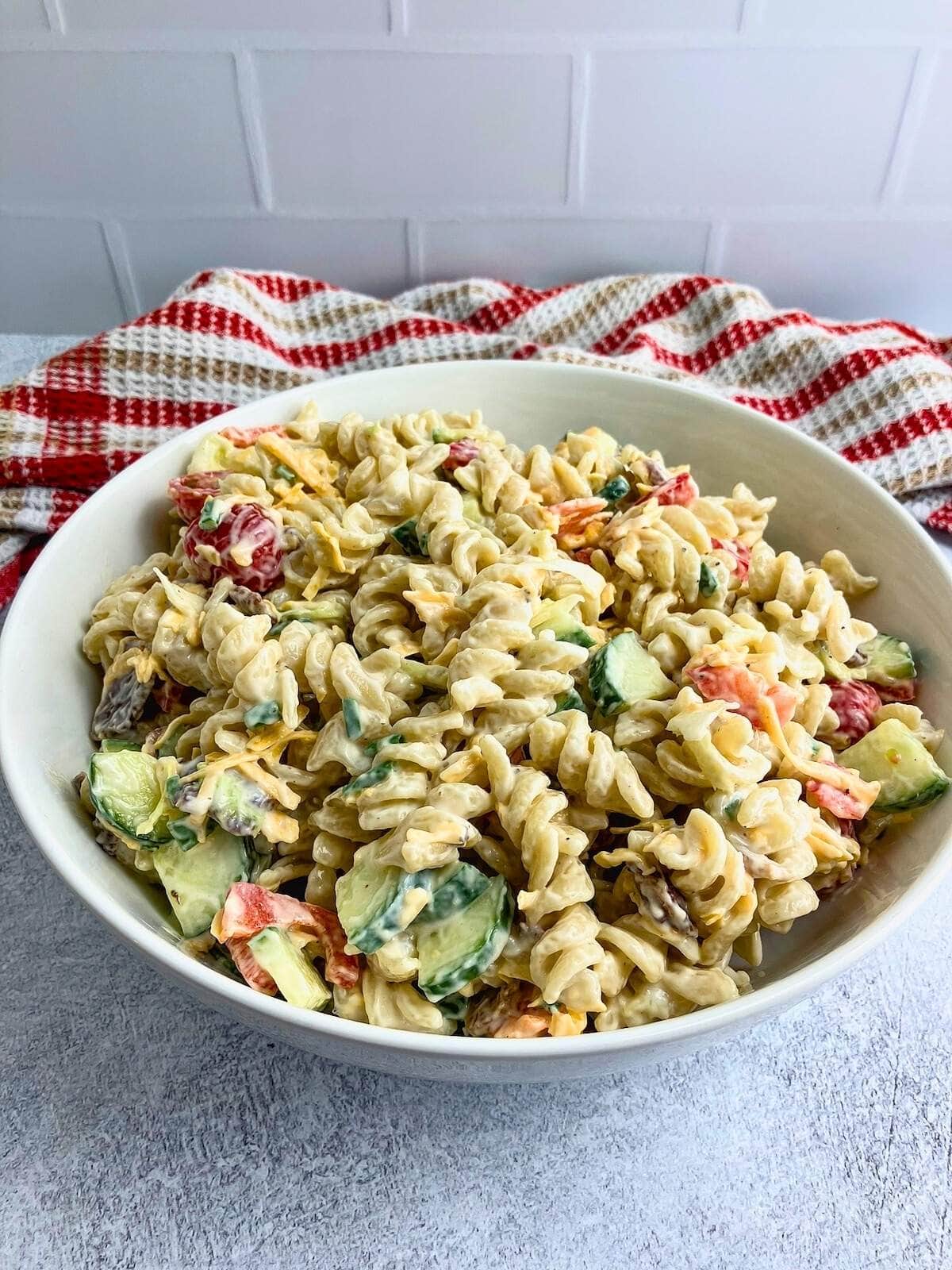 A large bowl of creamy bacon pasta salad.