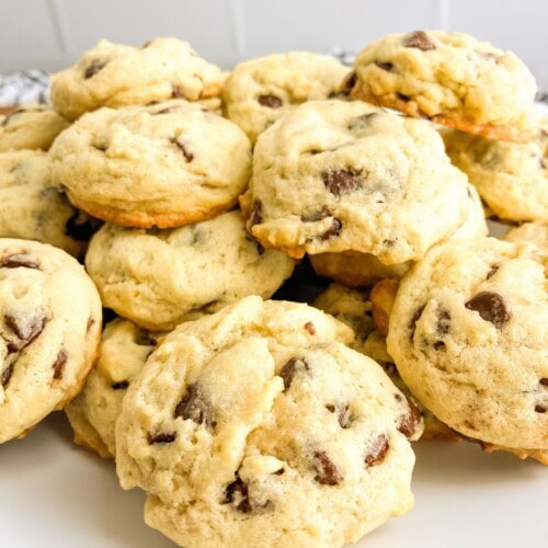 Homemade thick chocolate chip cookies on a white platter.