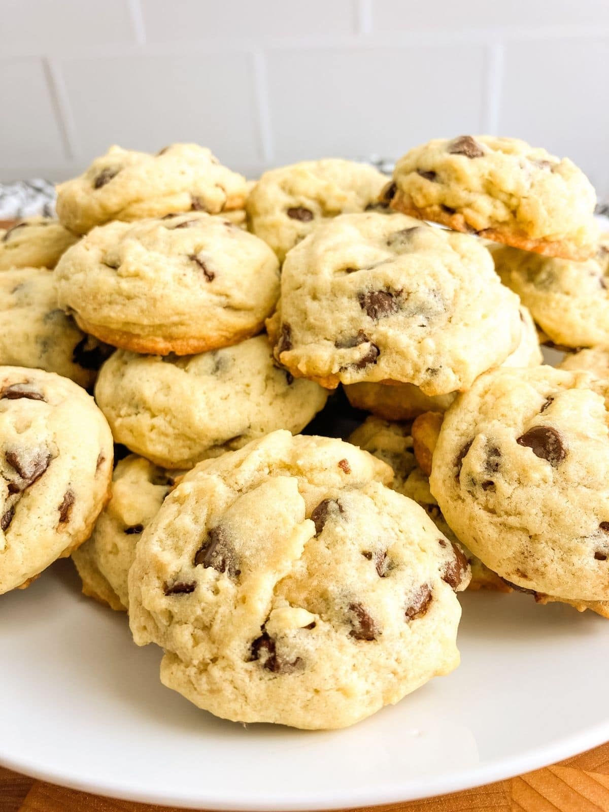 Homemade thick chocolate chip cookies on a white platter.