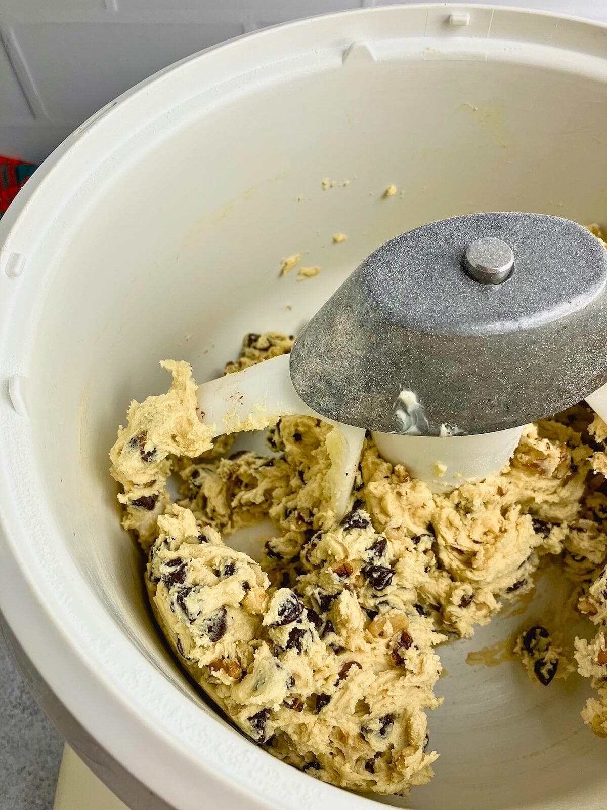 Chocolate chip walnut cookie dough is all mixed together in a stand mixer.